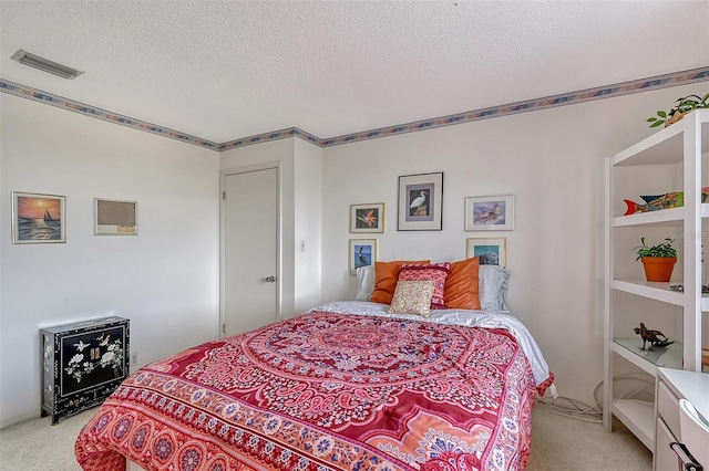 bedroom with light carpet and a textured ceiling