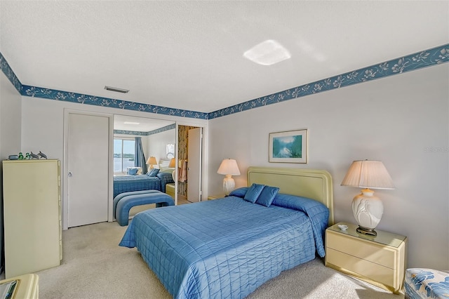 carpeted bedroom featuring a textured ceiling and a closet