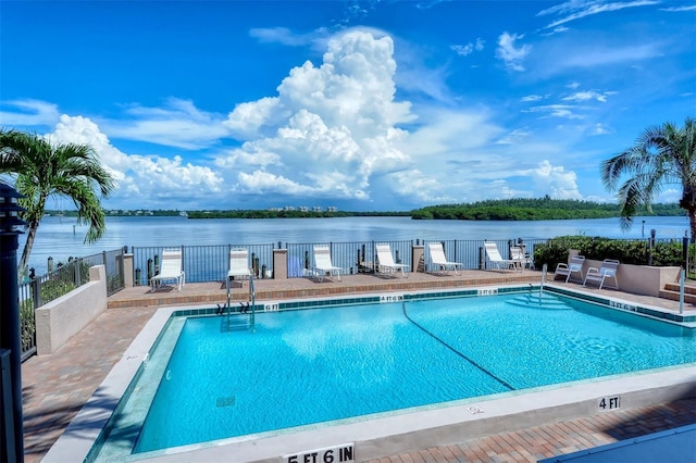 view of swimming pool featuring a water view and a patio