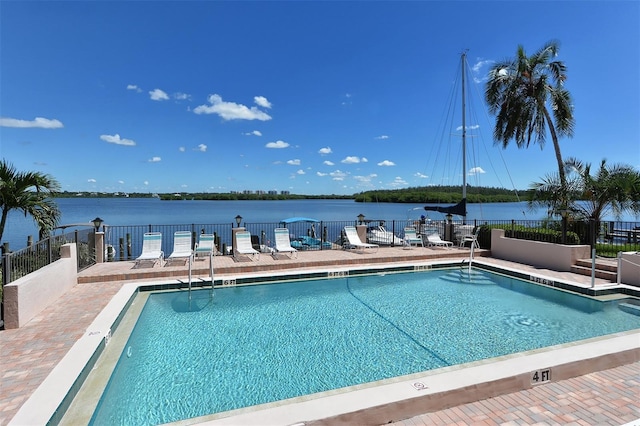 view of pool with a patio and a water view