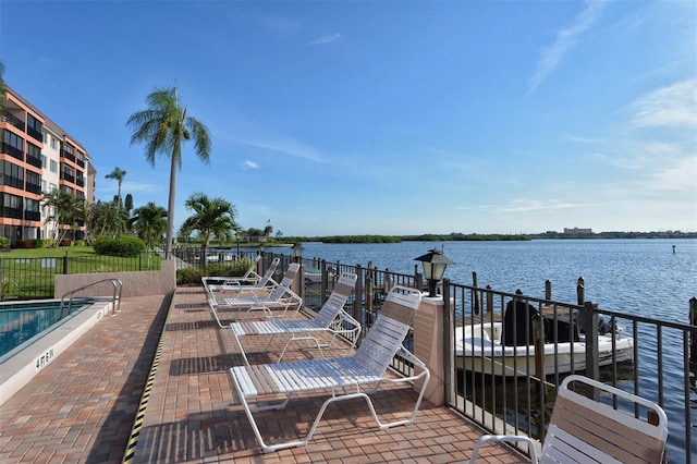 dock area featuring a water view and a patio area