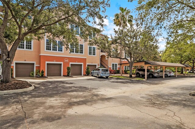 view of front of property featuring a garage and a carport