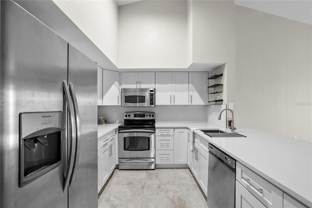 kitchen with sink, white cabinetry, light tile patterned floors, stainless steel appliances, and backsplash