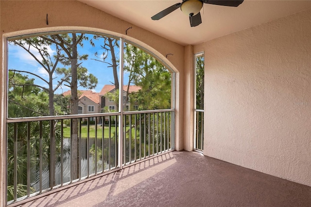 unfurnished sunroom with ceiling fan