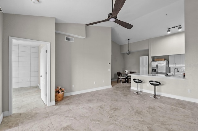 unfurnished living room featuring sink, vaulted ceiling, and ceiling fan