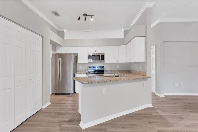 kitchen featuring light stone countertops, sink, stainless steel appliances, kitchen peninsula, and white cabinets