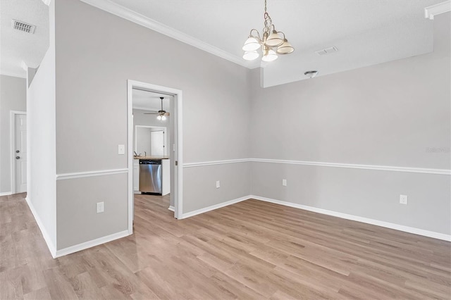 empty room featuring ceiling fan with notable chandelier, light wood-type flooring, and crown molding