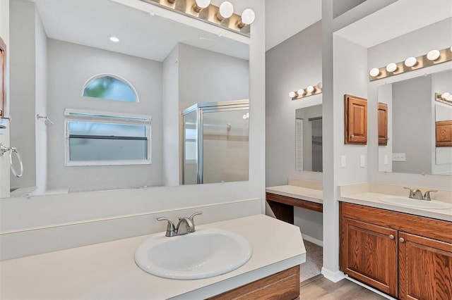 bathroom with hardwood / wood-style floors, vanity, and a shower with shower door