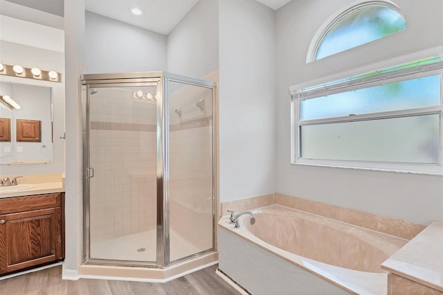 bathroom featuring hardwood / wood-style floors, vanity, and shower with separate bathtub