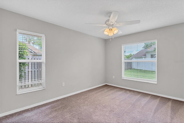 carpeted spare room featuring ceiling fan and a textured ceiling