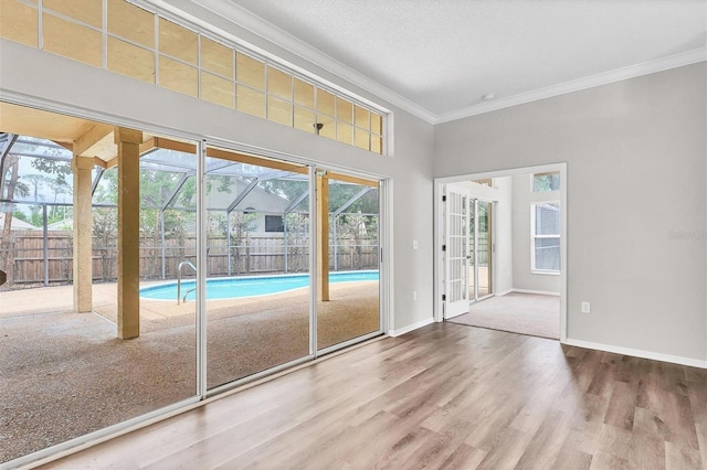 doorway to outside with hardwood / wood-style floors, ornamental molding, and a textured ceiling