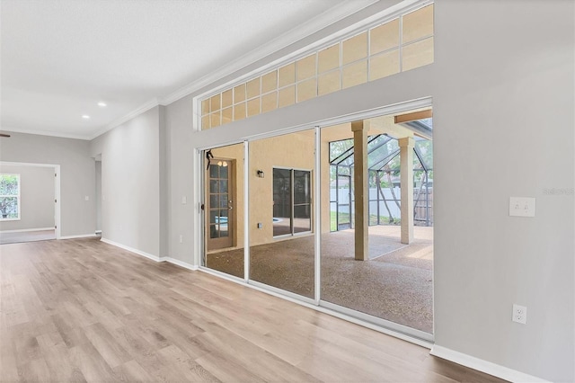 empty room featuring plenty of natural light, hardwood / wood-style floors, and ornamental molding