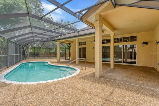 view of swimming pool featuring ceiling fan, a lanai, and a patio