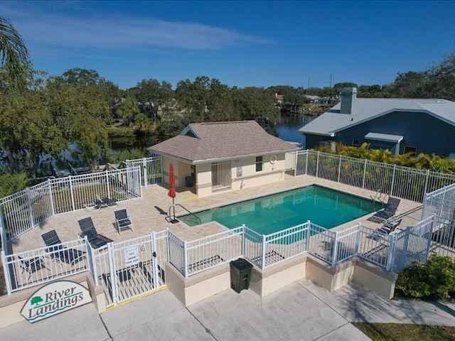 view of swimming pool featuring a water view and a patio