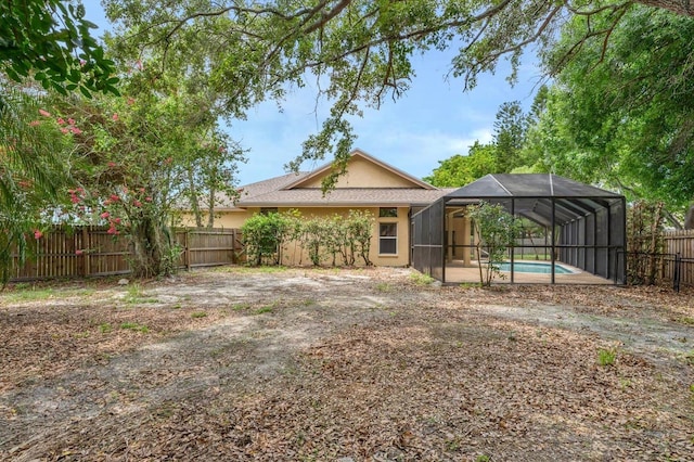 back of property featuring a fenced in pool and glass enclosure