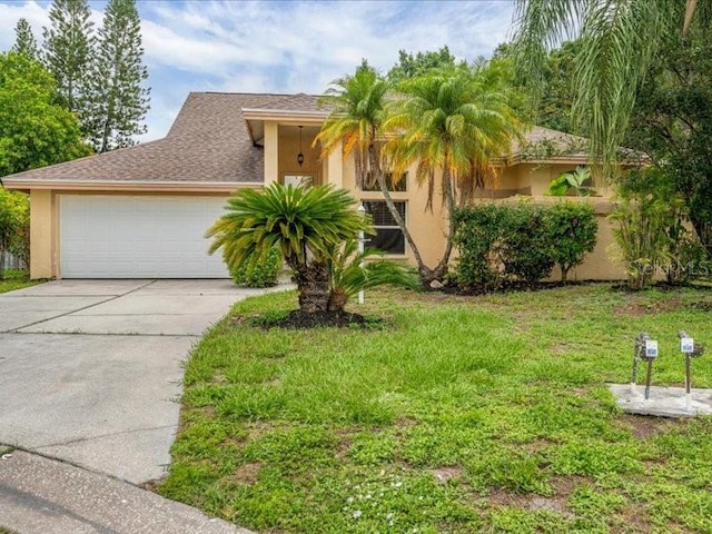 view of front of home with stucco siding, driveway, an attached garage, and a front lawn