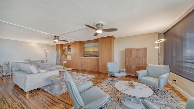 living room with ceiling fan and light hardwood / wood-style flooring