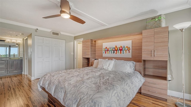 bedroom with ceiling fan, sink, crown molding, a closet, and light wood-type flooring