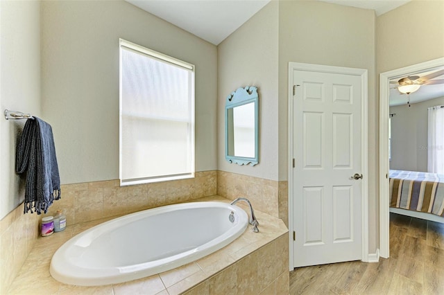 bathroom featuring a relaxing tiled tub and wood-type flooring