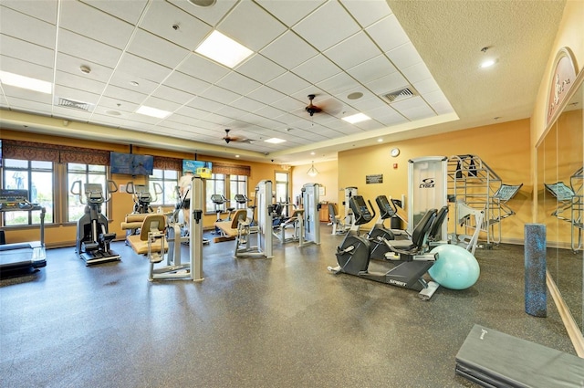 exercise room with a drop ceiling and ceiling fan