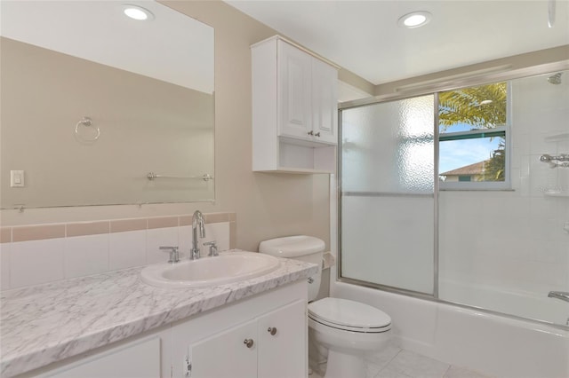 full bathroom featuring tile patterned floors, vanity, tasteful backsplash, toilet, and combined bath / shower with glass door