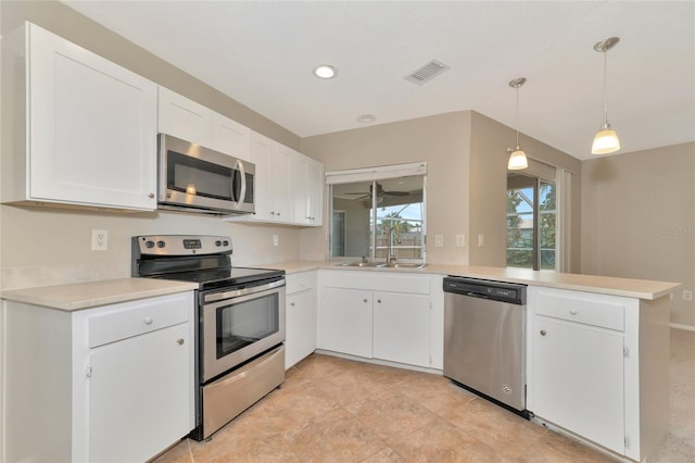 kitchen with kitchen peninsula, sink, stainless steel appliances, and white cabinetry