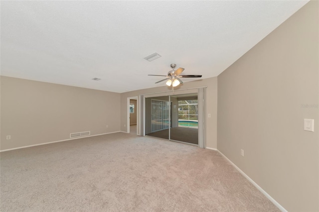 spare room with ceiling fan and light carpet