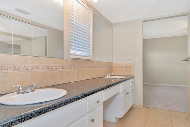 bathroom featuring tile patterned floors, vanity, and tasteful backsplash