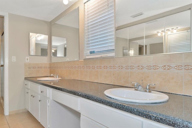 bathroom featuring decorative backsplash, tile patterned floors, and vanity