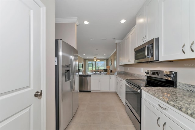 kitchen featuring light tile patterned flooring, sink, crown molding, appliances with stainless steel finishes, and white cabinets