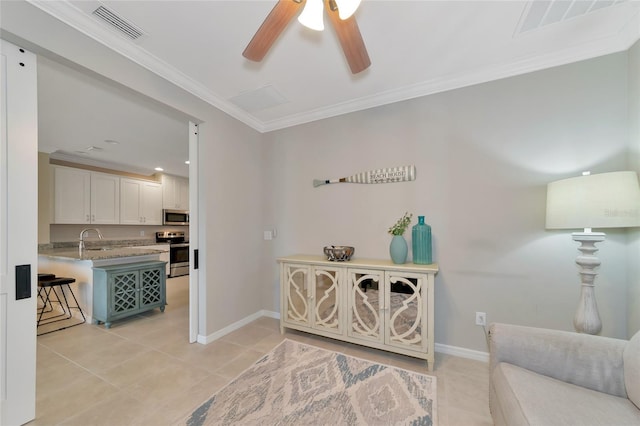 living area with light tile patterned floors, ornamental molding, sink, and ceiling fan