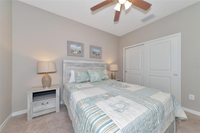 bedroom with light carpet, ceiling fan, and a closet