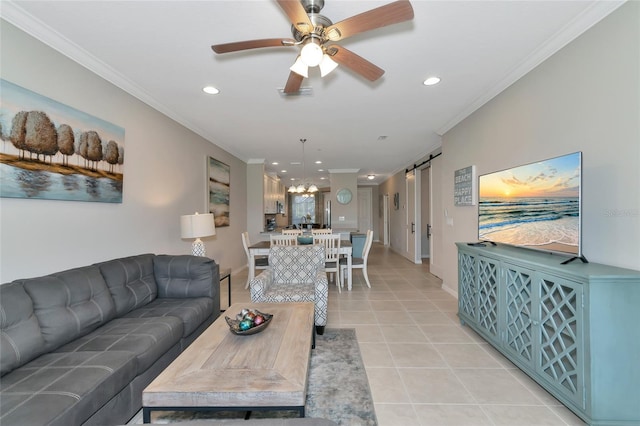 living room featuring ceiling fan, ornamental molding, a barn door, and light tile patterned floors