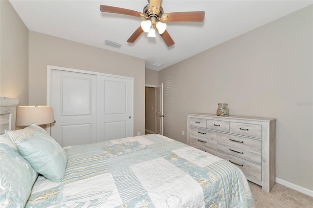 bedroom featuring light colored carpet, a closet, and ceiling fan