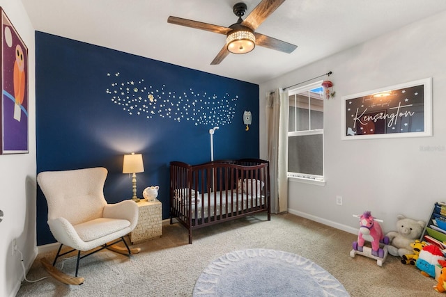 bedroom featuring a crib, carpet, and ceiling fan