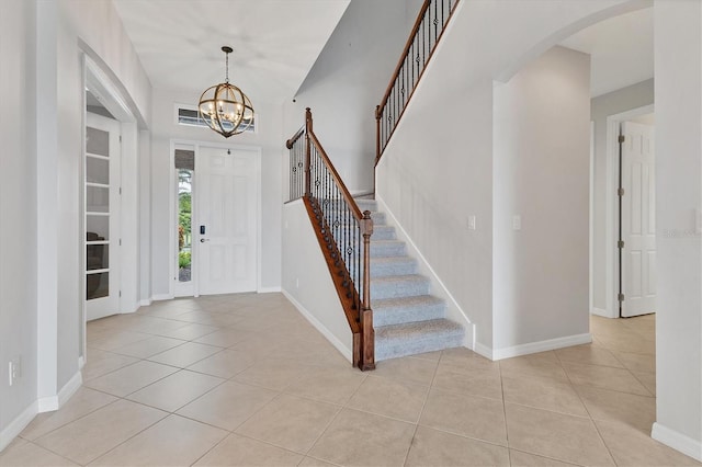 foyer with light tile patterned floors and an inviting chandelier