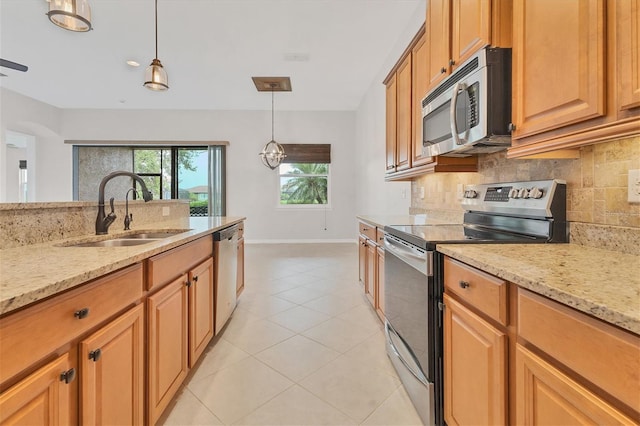 kitchen featuring decorative light fixtures, a notable chandelier, sink, light stone countertops, and appliances with stainless steel finishes