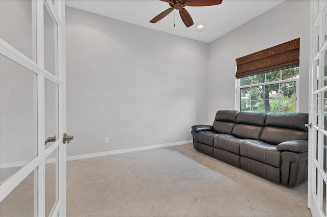 tiled living room featuring ceiling fan and french doors