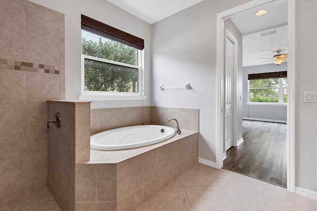 bathroom featuring ceiling fan, tile patterned floors, and plus walk in shower