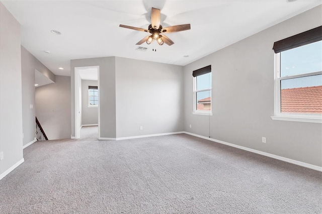 spare room with ceiling fan and carpet