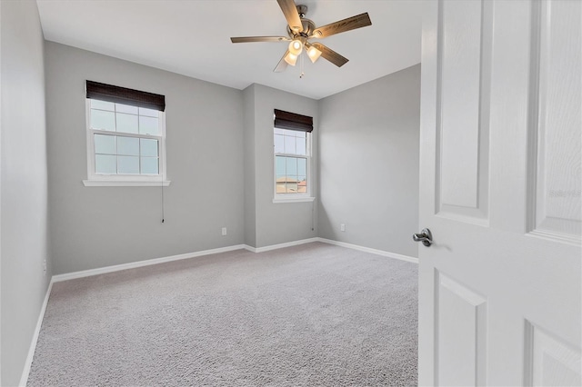 carpeted spare room with ceiling fan