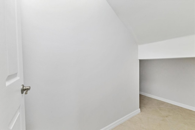 bonus room with lofted ceiling and light tile patterned flooring