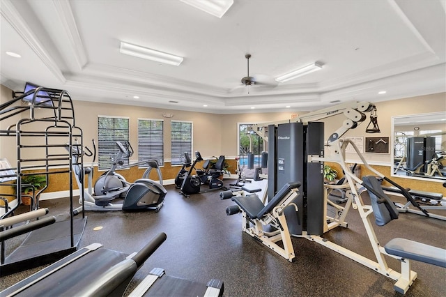 workout area featuring ceiling fan, crown molding, and a tray ceiling