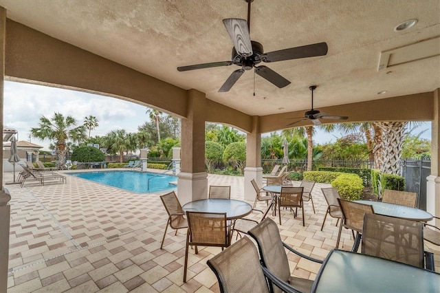 view of swimming pool with ceiling fan and a patio