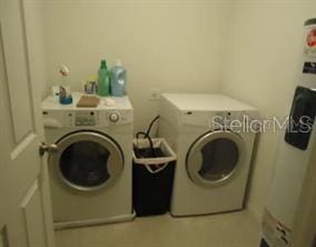 washroom featuring water heater and separate washer and dryer