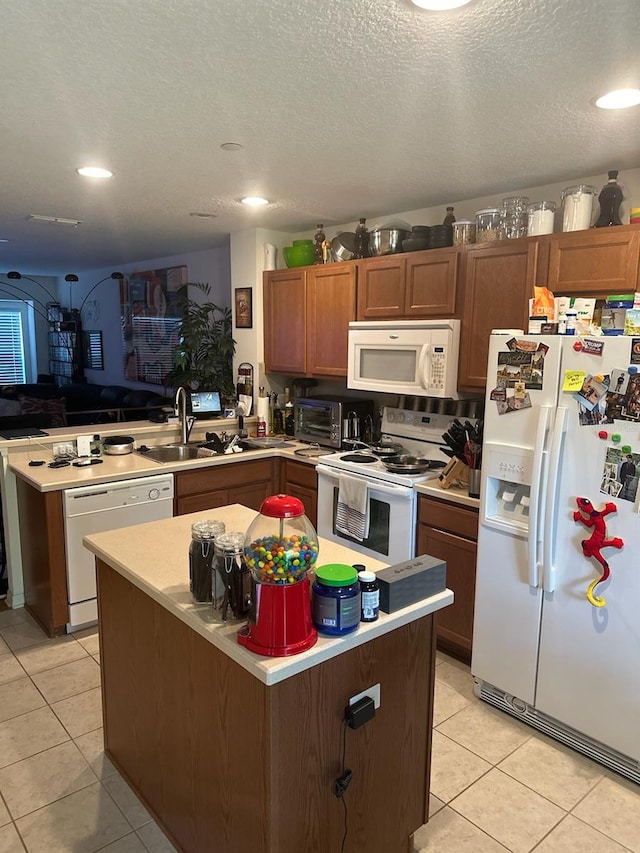 kitchen with a textured ceiling, white appliances, light tile patterned floors, kitchen peninsula, and sink