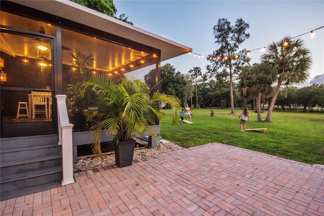 patio terrace at dusk featuring a yard