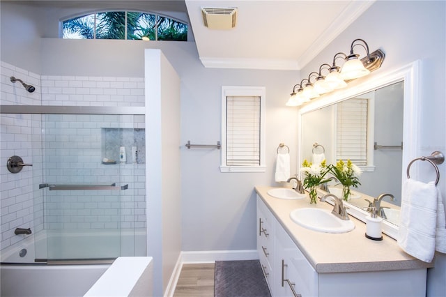 bathroom with shower / bath combination with glass door, wood-type flooring, vanity, and crown molding