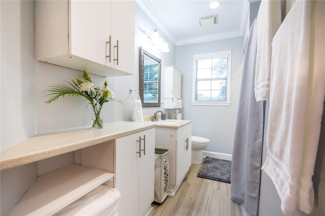 bathroom with hardwood / wood-style floors, vanity, toilet, and crown molding