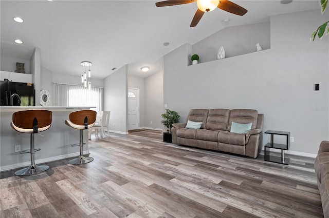 living room with wood-type flooring, ceiling fan, and vaulted ceiling